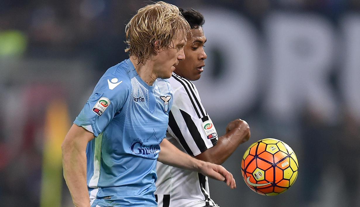 Pemain Juventus,  Alex Sandro (kanan) berebut bola dengan pemain Lazio, Dusan Basta pada lanjutan Liga Italia Serie A di Stadion Olimpico, Sabtu (5/12/2015) dini hari WIB. (AFP Photo/Alberto Pizzoli)