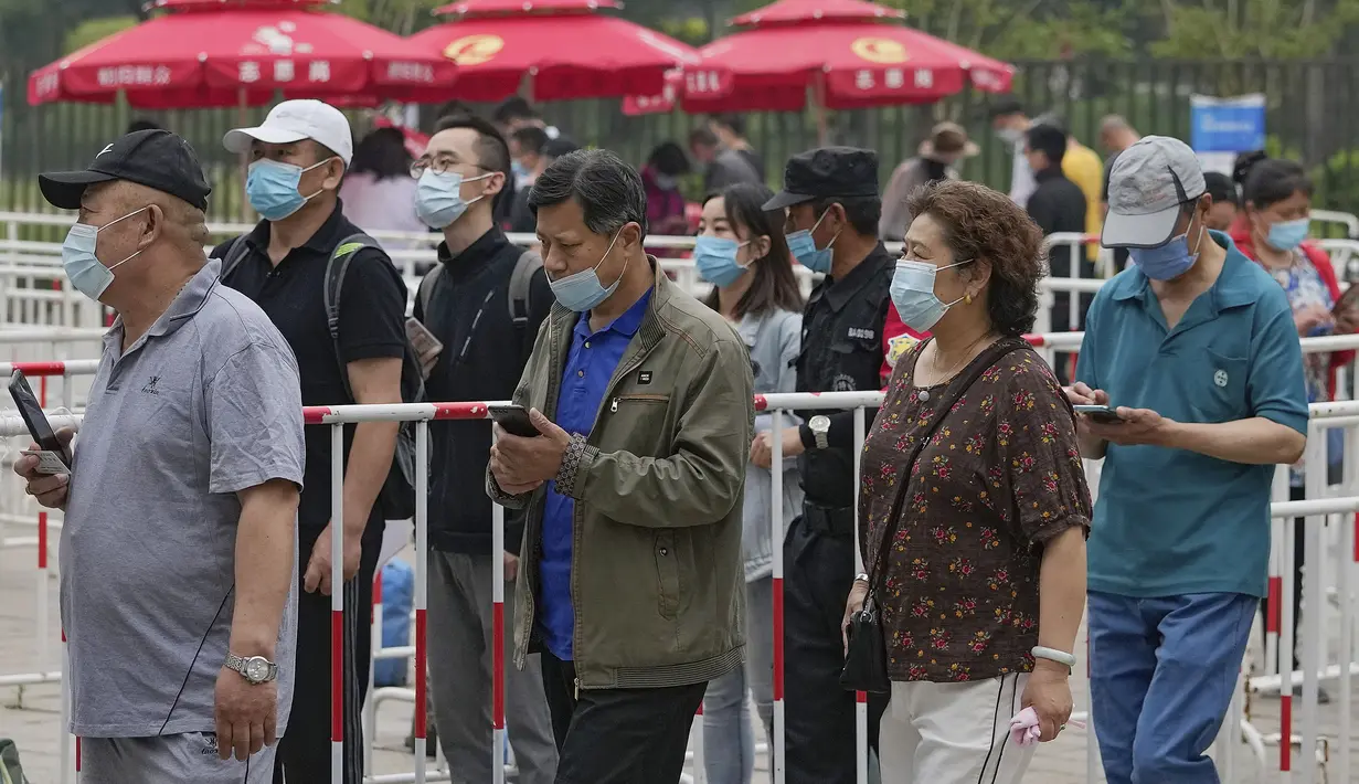 Warga mengenakan masker untuk membantu memutus rantai penyebaran virus corona saat antre menerima vaksin Sinopharm COVID-19 di Central Business District di Beijing, Rabu (2/6/2021). Sinopharm menjadi vaksin pertama dari negara non-Barat yang mendapatkan persetujuan dari WHO. (AP Photo/Andy Wong)