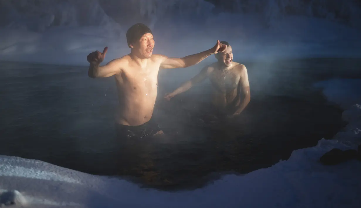 Pelari maraton terdingin di Dunia Internasional mandi dalam mata air hangat saat suhu minus 53 derajat (-63,4 Fahrenheit) di dekat Oymyakon, republik Sakha, juga dikenal sebagai Yakutia, Rusia, pada 22 Januari 2022. Sebanyak 65 pelari bersaing dalam suhu yang sangat rendah. (AP Photo/Ivan Nikiforov)