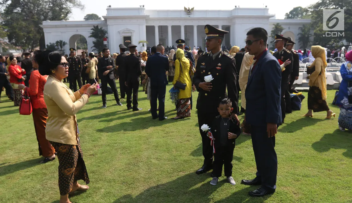 Perwira TNI-Polri bersiap untuk foto bersama orangtuanya usai dilantik Presiden Joko Widodo atau Jokowi di halaman Istana Merdeka, Jakarta Pusat, Selasa (16/7/2019). Jokowi melantik 259 perwira Akademi Militer, 117 Angkatan Laut, 99 Angkatan Udara, dan 306 Polri. (Liputan6.com/Angga Yuniar)
