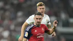 Gelandang Osasuna Moi Gomez berebut bola dengan gelandang Real Madrid Toni Kroos pada pekan ketujuh Liga Spanyol 2022/2023 di Stadion Santiago Bernabeu, Senin dini hari WIB (3/10/2022). Real Madrid hanya mampu bermain imbang 1-1 saat menjamu Osasuna. (AP Photo/Manu Fernandez)