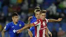 Gelandang Atletico Madrid, Marcos dan bek Getafe, Mathias Olivera berebut bola pada laga pekan keenam Liga Spanyol di Stadion Coliseum Alfonso Perez, Rabu (22/9/2021) dini hari WIB. Luis Suarez memborong dua gol saat Atletico Madrid mengalahkan Getafe 2-1. (AP Photo/Manu Fernandez)