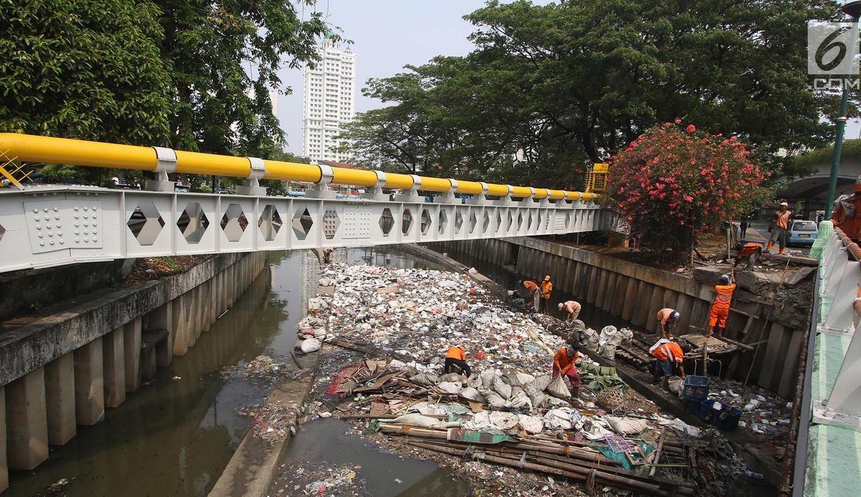 Petugas PPSU mencoba mengurai sampah yang menumpuk di Kali Cideng, Jakarta Pusat, Senin (11/9). Selain penampakannya yang tidak nyaman dipandang, bau yang menyengat juga mengganggu warga yang melintas di kawasan tersebut. (Liputan6.com/Immanuel Antonius)