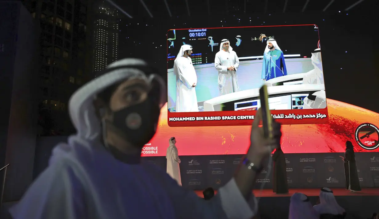 Seorang pria merekam video dengan ponselnya saat merayakan suksesnya misi Hope memasuki orbIt Planet Mars, di Dubai, Selasa (9/2/2021). Badan antariksa UEA hari Selasa (9/2) mengumumkan wahana Mars tak berawaknya telah tiba di planet merah itu dan berhasil memasuki orbit. (AP Photo/Kamran Jebreili)