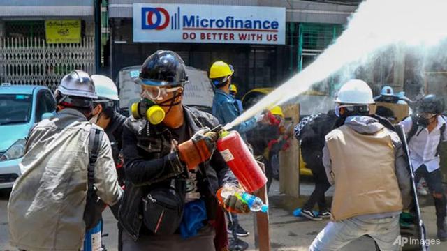 Pengunjuk rasa anti-kudeta mengeluarkan alat pemadam kebakaran untuk melawan dampak gas air mata yang ditembakkan oleh polisi selama demonstrasi di Yangon, Myanmar, pada 4 Maret 2021.