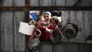 Anak-anak Palestina memberi isyarat saat mereka mengantre untuk mengambil makanan di titik distribusi makanan gratis di kamp pengungsi Nuseirat, Jalur Gaza tengah, pada 3 April 2025. (Eyad BABA/AFP)