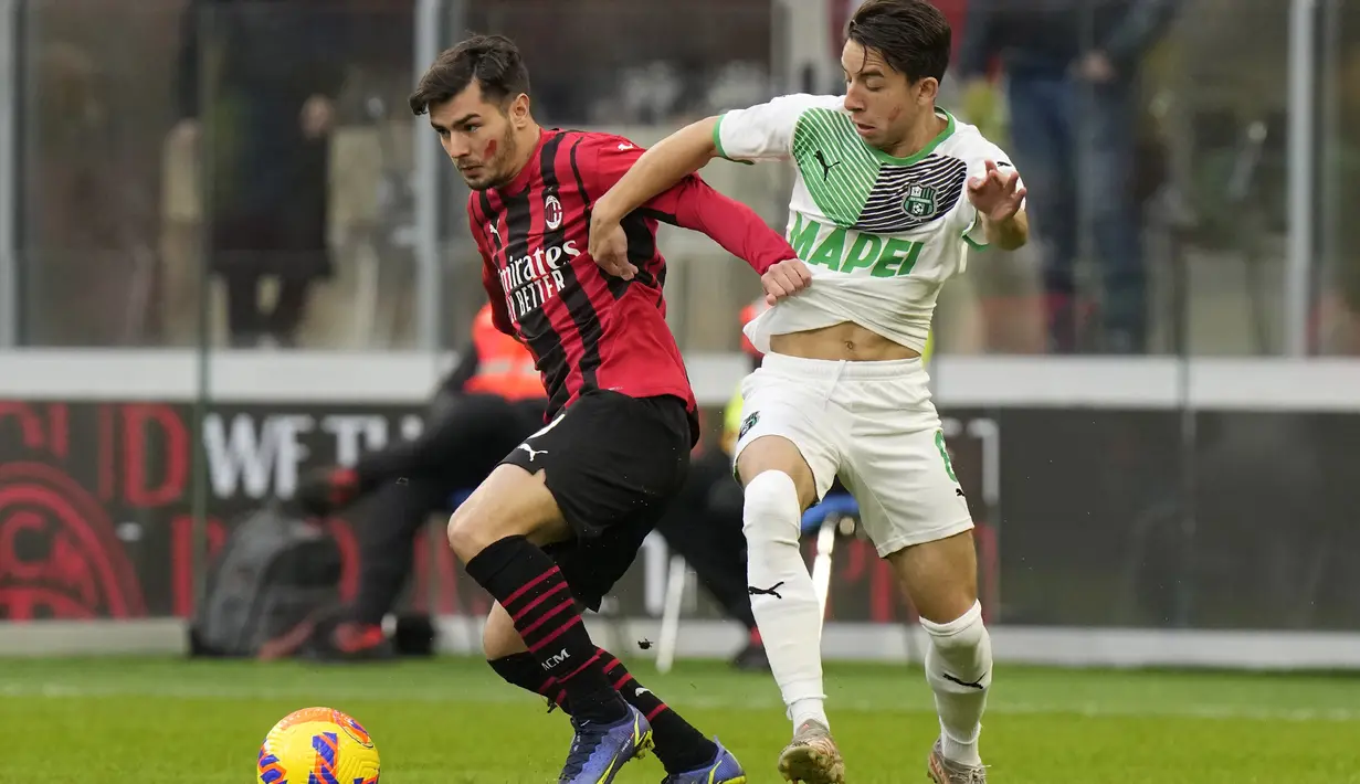 Gelandang AC Milan, Brahim Diaz mengontrol bola dari kawalan pemain Sassuolo, Maxime Lopez pada pertandingan lanjutan Liga Serie A Italia di stadion San Siro, Minggu (28/11/2021). AC Milan kalah atas Sassuolo 1-3. (AP Photo/Luca Bruno)