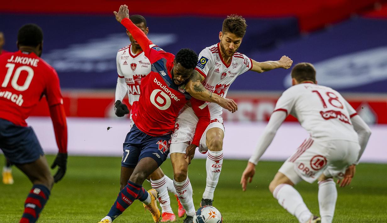 Striker Lille, Jonathan Bamba (tengah, kiri) berebut bola dengan gelandang Brest, Paul Lasne dalam laga lanjutan Liga Prancis 2020/21 pekan ke-25 di The Stade Pierre Mauroy, Lille, Minggu (14/2/2021). Lille bermain imbang 0-0 dengan Brest. (AP/Michel Spingler)