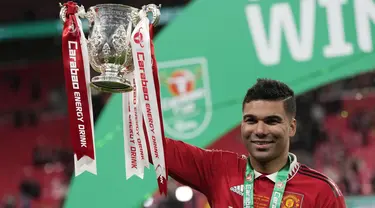 Gelandang Manchester United, Casemiro memegang trofi Carabao Cup 2022/2023 selama perayaan juara usai mengalahkan Newcastle United pada laga final di Stadion Wembley di London, Senin dini hari WIB (27/2/2023). Manchester United atau MU menang 2-0 atas Newcastle United di final Carabao Cup 2022/2023. (AP Photo/Alastair Grant)