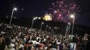 Orang-orang berkumpul di jembatan untuk menyaksikan kembang api Hari Bastille di Lyon, Prancis tengah, Jumat, 14 Juli 2023. (AP Photo/Laurent Cipriani)