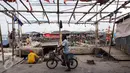 Seorang warga mengendarai sepeda di Tempat Pelelangan Ikan Cilincing, Jakarta Utara, Rabu (8/2). (Fery Pradolo/Liputan6.com)