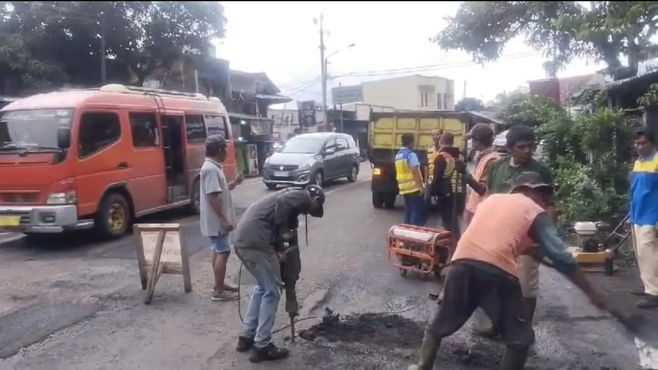 Sejumlah pekerja jalan tengah melakukan penambalan jalan di jalur nasional Limbangan-Nagreg menjelang puncak arus balik libur panjang isra mikraj-imlek 2025. (Liputan6.com/Jayadi Supriadin)