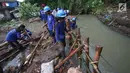 Pekerja menyelesaikan pembuatan tanggul darurat di kawasan Jatipadang, Jakarta, Rabu (22/11). Jebolnya tanggul Kali Pulo di kawasan tersebut menyebabkan puluhan rumah terendam banjir. (Liputan6.com/Immanuel Antonius)
