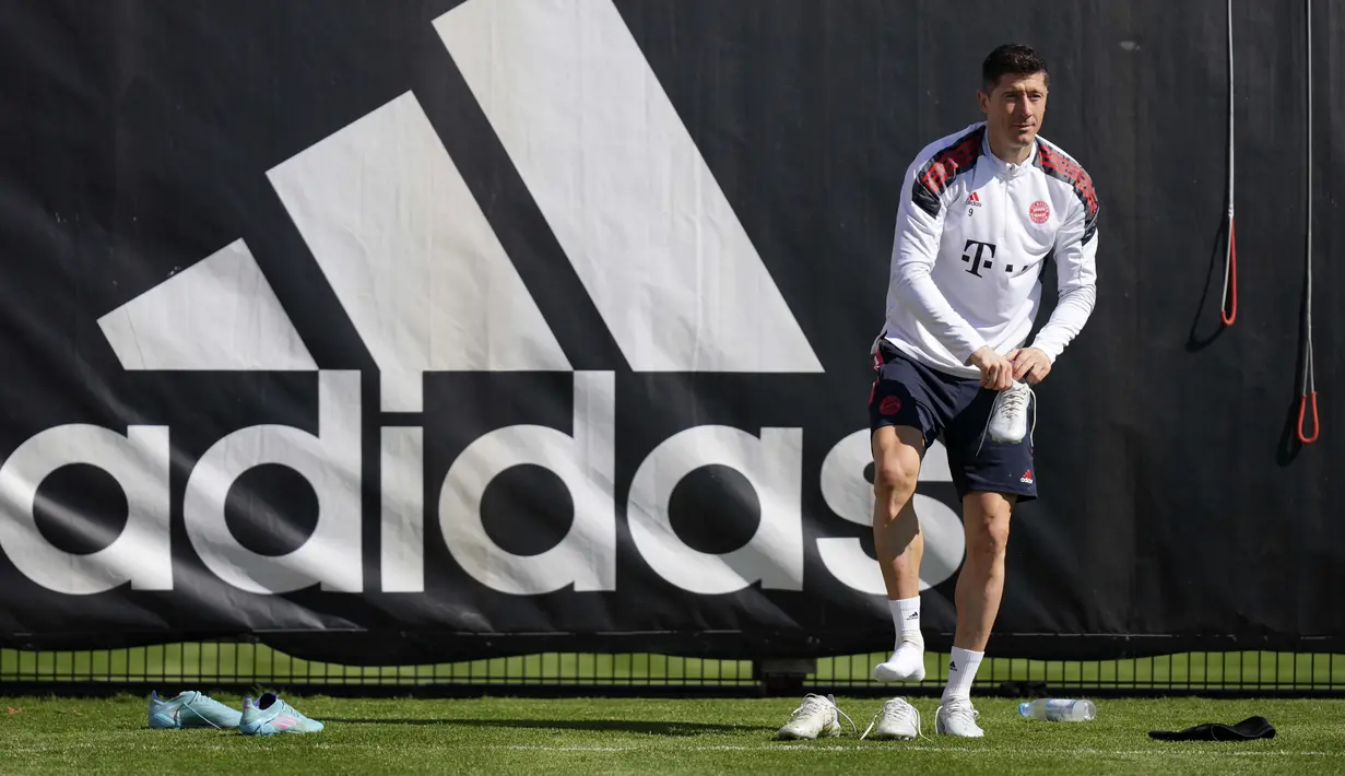 Penyerang Bayern Munchen Robert Lewandowski mengganti sepatunya selama sesi latihan sebelum leg kedua babak perempat final Liga Champions 2021/22 di Munich, Jerman, Senin (11/4/2022). Bayern Munchen akan menjamu Villarreal pada Rabu 13 April 2022 dini hari WIB. (AP Photo/Matthias Schrader)