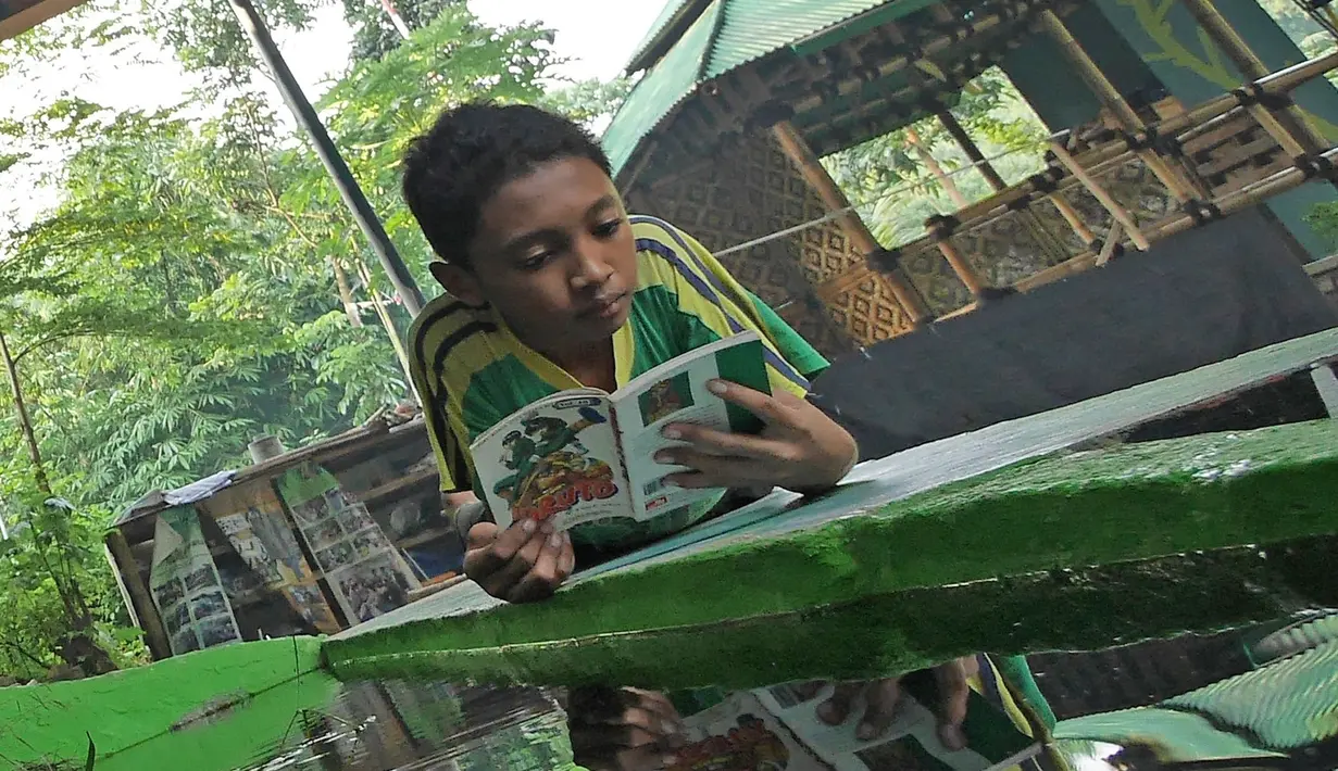 Anak-anak membaca buku di Saung Pustaka Air di Depok, Jawa Barat, (30/5). Perpustakaan ini menjadi sarana edukasi untuk menjaga dan mengenalkan area konservasi keanekaragaman hayati. (Liputan6.com/Herman Zakharia)