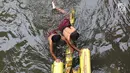 Anak-anak berenang menggunakan batang pohon pisang di bantaran Sungai Ciliwung, Jakarta, Selasa (15/5). Aktivitas tersebut berbahaya bagi kesehatan dan keselamatan mereka. (Liputan6.com/Immanuel Antonius)