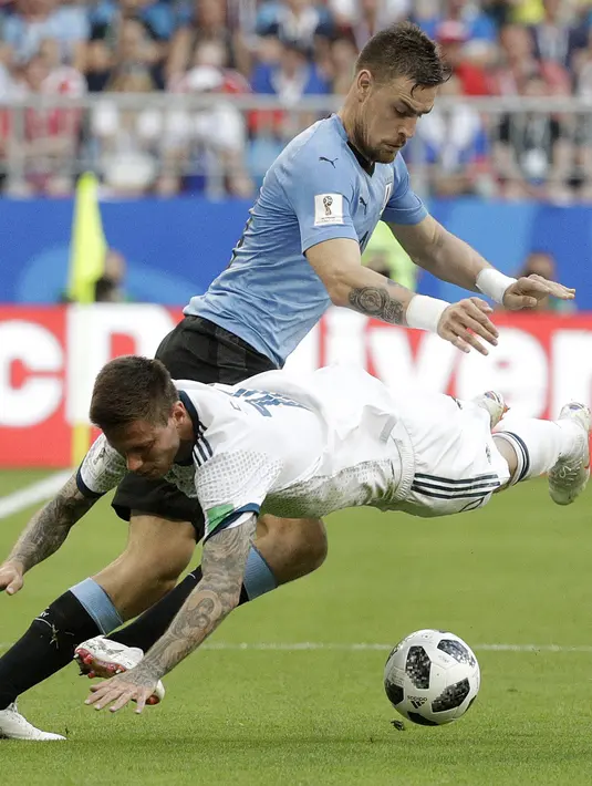 Pemain Rusia, Fyodor Smolov (kanan) jatuh saat berebut bola dengan pemain Uruguay, Sebastian Coates pada laga grup A Piala Dunia 2018 di Samara Arena, Samara, Rusia, (25/6/2018). Uruguay menang 3-0. (AP/Gregorio Borgia)