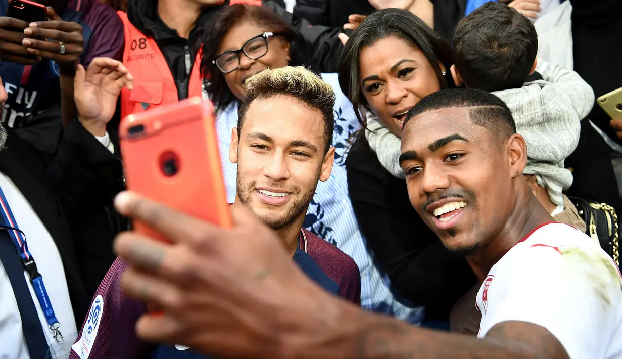 Penyerang PSG, Neymar berfoto bersama dengan pemain Bordeaux, Malcom usai pertandingan Ligue 1 di stadion Parc des Princes di Paris (30/9). Kedua pemain asal Brasil ini terlihat akrab usai pertandingan. (AFP Photo/Franck Fife)