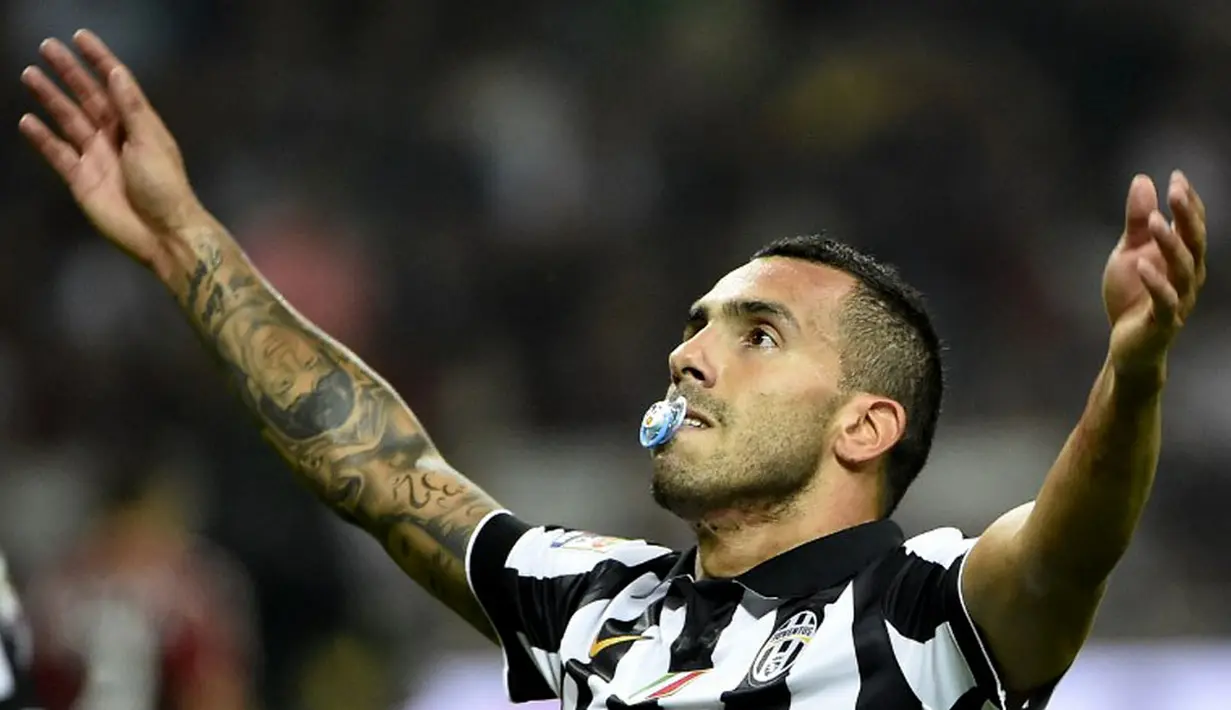 Pemain depan Juventus, Carlos Tevez, merayakan golnya ke gawang AC Milan di laga lanjutan Seri A Italia di Stadion San Siro, (20/9/2014). (AFP PHOTO/Olivier Morin)