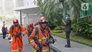 Petugas berlarian saat berusaha memadamkan kebakaran di Gedung Cyber 1, Jakarta, Kamis (2/12/2021). Sampai saat ini, penyebab kebakaran masih belum diketahui. (Liputan6.com/Herman Zakharia)