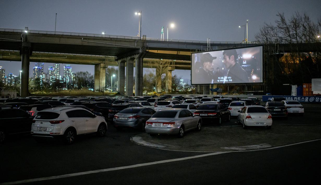 Sebuah layar terbuka menunjukkan film yang sedang diputar di sebuah bioskop kendara atau drive-in cinema di Seoul, Korea Selatan, 21 Maret 2020. Jenis bioskop ini menjadi pilihan yang lebih bagi warga Seoul untuk menikmati film di tengah pandemi virus corona Covid-19. (Ed JONES/AFP)
