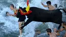 Aksi peserta yang terjun kelaut saat dikejar banteng pada festival tradisional Spanyol Bull Run atau  "Bous a la mar" (Bull in the sea) di  Pelabuhan Denia's dekat Alicante, (9/7/2016). (AFP/Jose Jordan)
