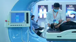 Peserta pameran mengoperasikan perangkat medis yang ditampilkan dalam Pameran Kesehatan Dunia Kedua di Wuhan, Provinsi Hubei, China pada 11 November 2020. Ajang selama empat hari itu berfokus memamerkan ilmu pengetahuan dan teknologi mutakhir dalam industri kesehatan global. (Xinhua/Cheng Min)