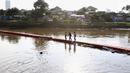 Anak-anak melintasi jembatan yang ada di Kanal Banjir Barat, Jakarta, Jumat (23/3). Selain mahalnya sewa kolam renang, berenang Kanal Banjir Barat dipilih anak-anak tersebut karena minimnya lahan bermain. (Liputan6.com/Immanuel Antonius)