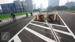 Warga bersepeda di sepanjang jalan layang Transjakarta rute Cileduk-Tendean di Jakarta, Minggu (26/2). Belum beroperasinya jalan sepanjang 9,3 km tersebut dimanfaatkan warga untuk mengisi kegiatan saat Minggu pagi. (Liputan6.com/Immanuel Antonius)