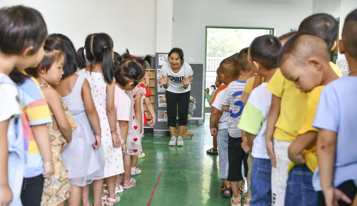 Anak-anak memperkenalkan diri mereka dibantu guru di taman kanak-kanak lokasi relokasi wilayah Sansui, Provinsi Guizhou, China, 31 Agustus 2020. Guizhou melakukan segala upaya untuk membangun atau memperluas 669 sekolah di lokasi relokasi tersebut. (Xinhua/Yang Wenbin)