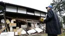 Seorang warga Jepang di depan sebuah bangunan yang rusak akibat diguncang gempa 6,8 SR, Sabtu (22/11/2014). (JAPAN OUT AFP PHOTO/Jiji Press)