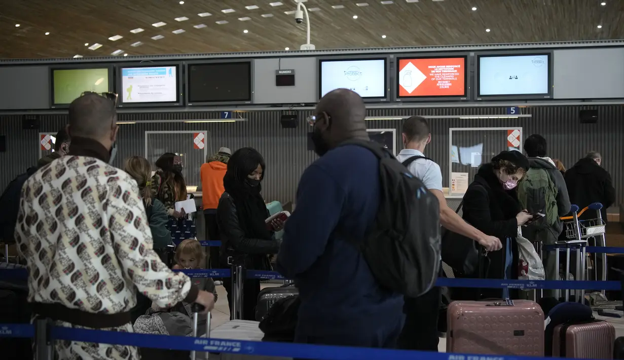 Pelancong ke Amerika Serikat menunggu di meja check-in di bandara Charles de Gaulle, utara Paris, Senin (8/11/2021).  AS pada Senin mencabut pembatasan perjalanan dari daftar panjang negara termasuk Meksiko, Kanada, dan sebagian besar Eropa. (AP Photo/Christophe Ena)