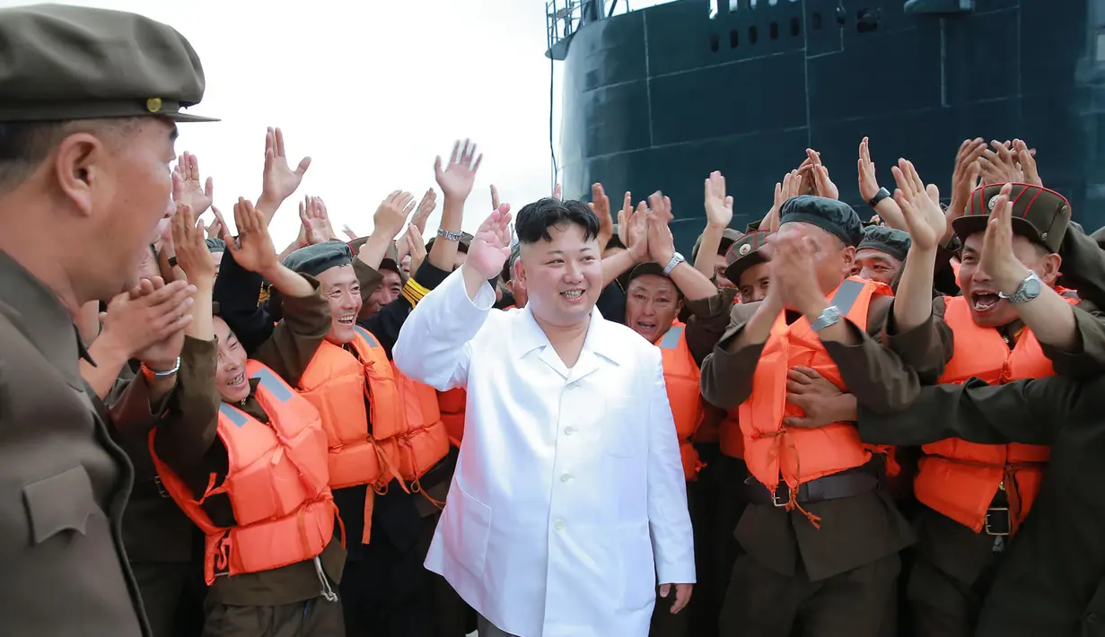 Pemimpin Korut, Kim Jong-un menyapa pasukannya sebelum tes tembakan rudal balistik dari kapal selam, Pyongyang (25/8). Peluncuran rudal disinyalir sebagai bentuk protes atas latihan militer gabungan Korsel-AS. (AFP PHOTO/KCNA)