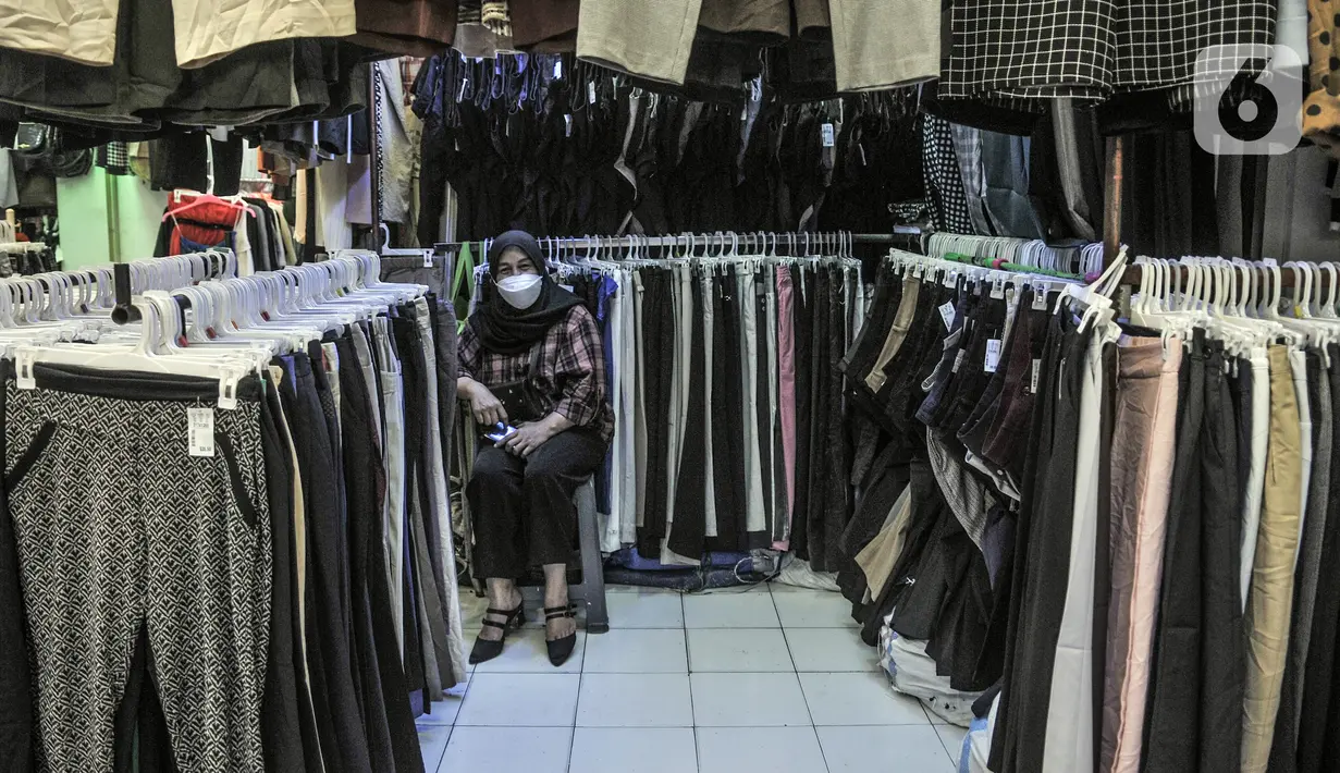 Pedagang menunggu pembeli pakaian bekas impor di Pasar Senen, Jakarta, Kamis (4/3/2021). Sepinya penjualan diperparah dengan rumor pakaian bekas impor berpotensi menyebarkan virus COVID-19. (merdeka.com/Iqbal S. Nugroho)