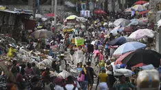 Seorang perempuan membawa baskom dengan barang-barangnya di pasar Petion-Ville di Port-au-Prince, empat hari setelah pembunuhan Presiden Haiti Jovenel Moise, Minggu (11/7/2021). Moïse tewas dibunuh dalam serangan di kediaman pribadinya, pada Rabu 7 Juli 2021 dini hari. (AP Photo/Matias Delacroix)