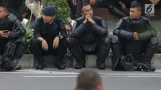 Personil kepolisian dari satuan Brimob beristirahat saat menjaga aksi unjuk rasa yang dilakukan Gerakan Nasional Kedaulatan Rakyat di depan Gedung Bawaslu, Jakarta, Selasa (21/5/2019). Ribuan aparat keamanan gabungan diterjunkan untuk mengamankan jalannya aksi. (Liputan6.com/Helmi Fithriansyah)