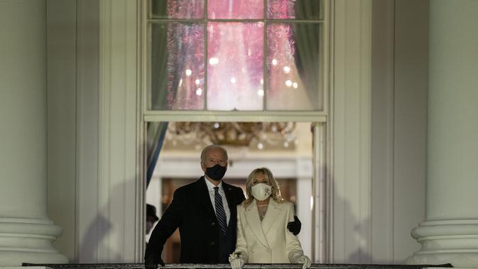 Jill dan Joe Biden menyaksikan kembang api dari balkon Gedung Putih, 20 Januari 2021.  (AP Photo/Evan Vucci)