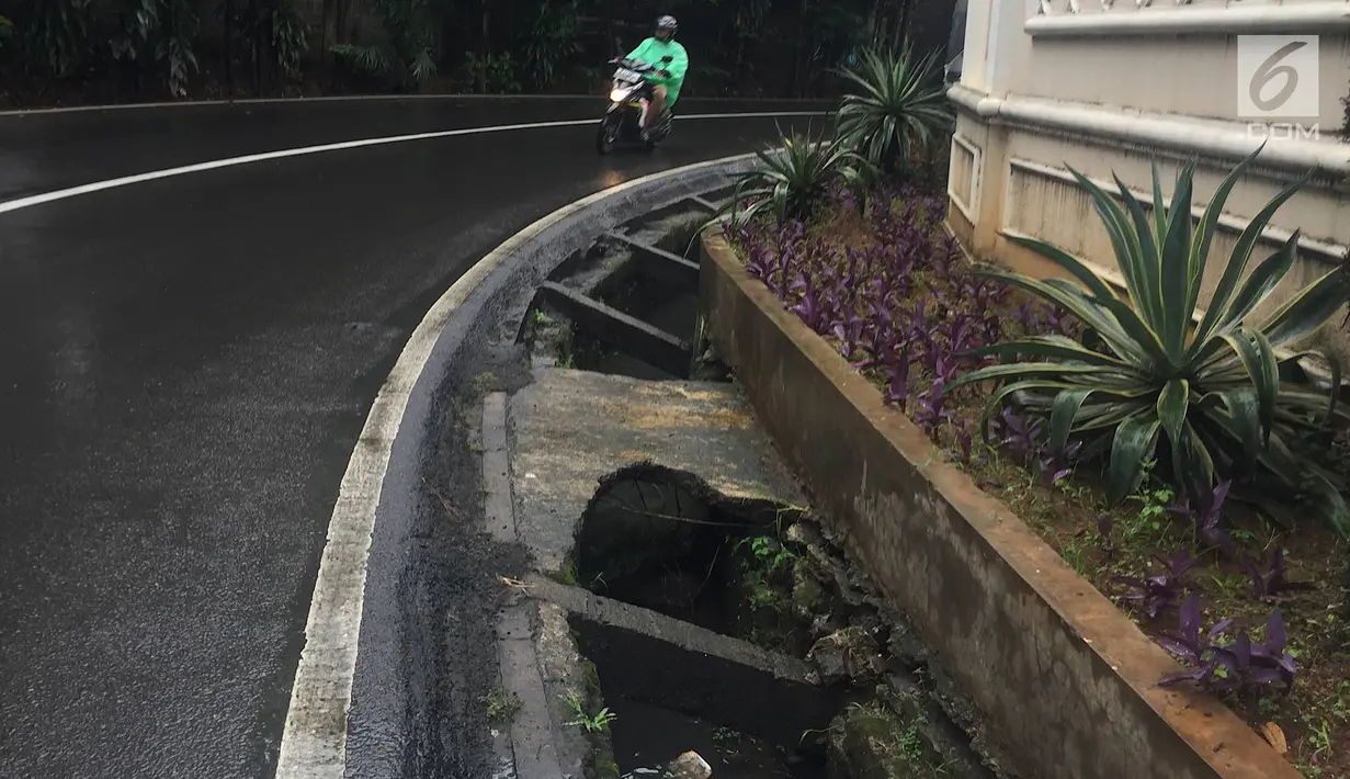 Pengendara melintas di samping selokan tanpa penutup di Jalan Mohammad Kahfi I, Jagakarsa, Jakarta, Selasa (22/1). Selain membahayakan pejalan kaki, kondisi tersebut juga berbahaya bagi pengendara terutama saat malam hari. (Liputan6.com/Immanuel Antonius)