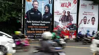 Kendaraan melintas dekat alat peraga kampaye Pilkada DKI 2017 yang berisi nama Cagub-Cawagub di Tugu Tani, Jakarta, Minggu  (20/11). KPUD DKI Jakarta mulai memasang baliho berukuran 4 m x 6 m di sejumlah titik di ibu kota. (Liptan6.com/Faizal Fanani)