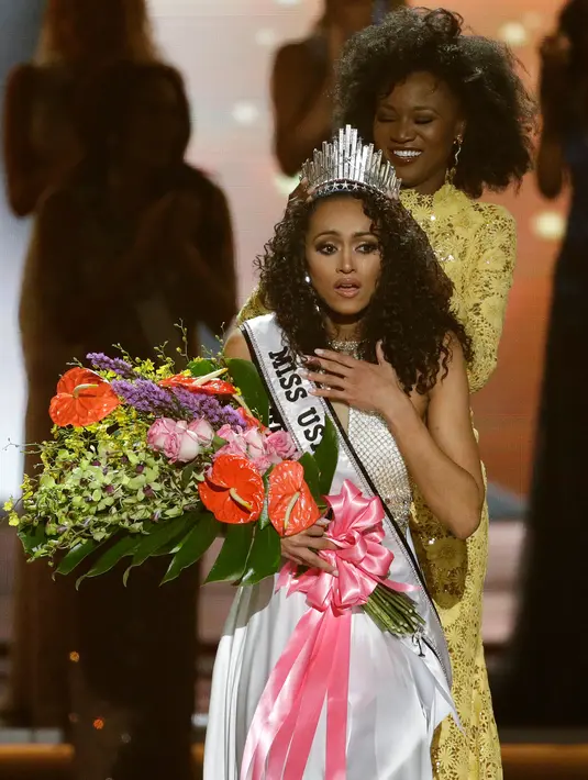 Miss District of Columbia, Kara McCullough bereaksi saat disematkan mahkota Miss USA 2017 di Las Vegas, Minggu (14/5). Di ajang yang memasuki tahun ke-66, Kara berhasil menyisihkan 50 kontestan dari seluruh penjuru Amerika. (AP Photo/John Locher)