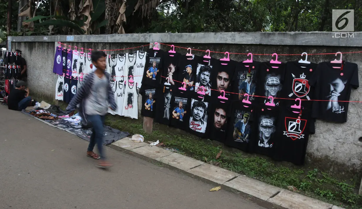 Penjual menjajakan kaos dagangannya di luar lokasi Konser Situs Budaya, kawasan Depok, Jawa Barat, Sabtu (3/3). Dalam Konser kali ini, Iwan Fals dan Band akan membawakan beberapa lagu andalan serta beberapa lagu daerah. (Liputan6.com/Arya Manggala)