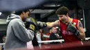 Perdana Menteri Kanada, Justin Trudeau mengarahkan pukulan ke petinju profesional Yuri Foreman di Gleason Boxing Gym di Brooklyn borough New York, AS (21/4). (REUTERS/Carlo Allegri)