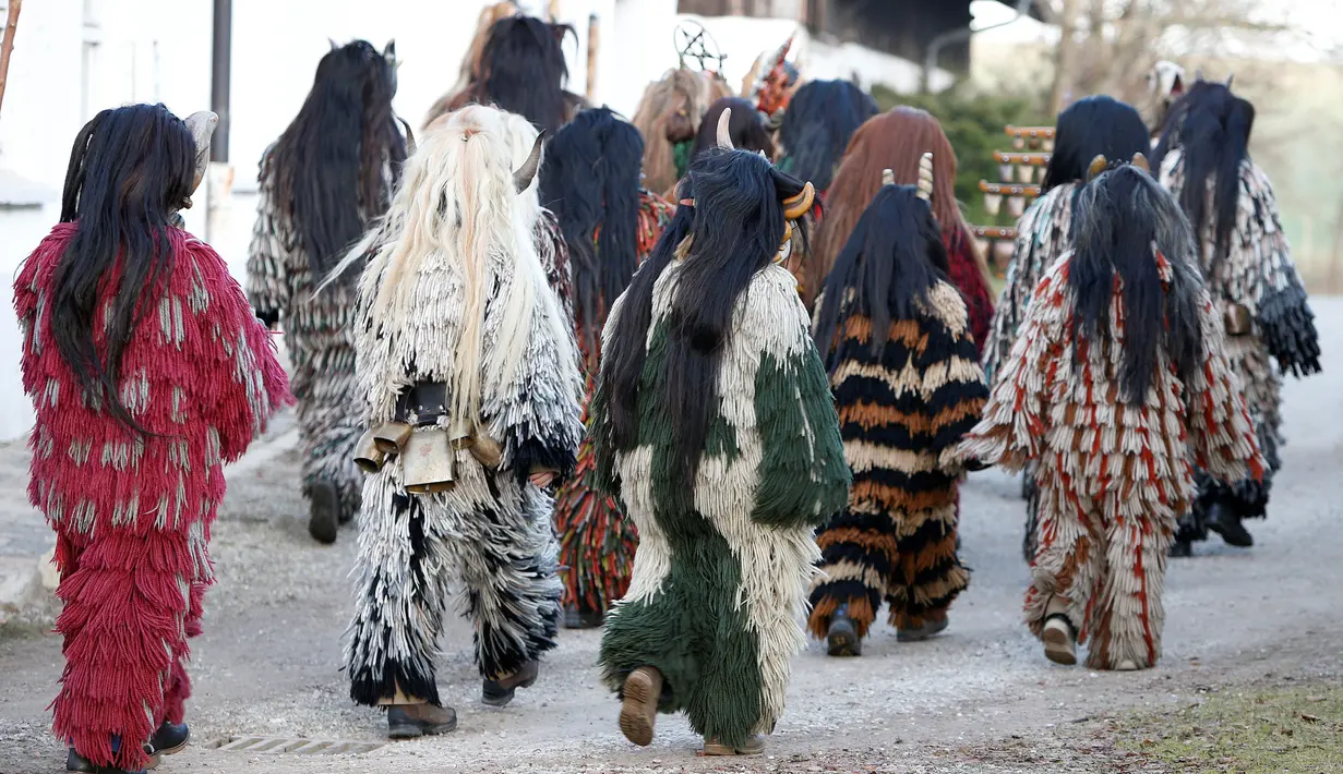 Rombongan peserta yang mengenakan kostum iblis bersiap mengikuti parade tardisional Perchtenlauf di Osterseeon dekat Munchen, Jerman (17/12). Acara ini bertujuan untuk mengusir hantu-hantu musim dingin. (Reuters/Michaela Rehle)