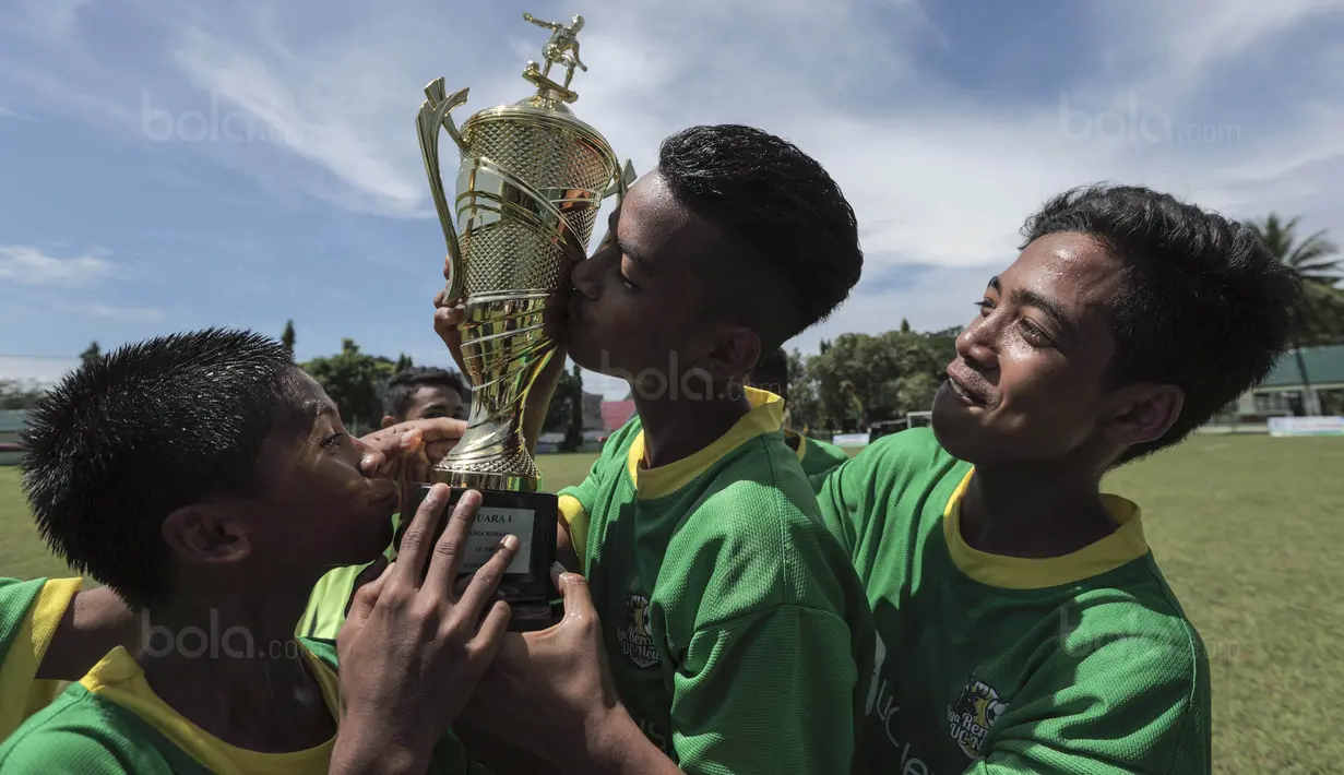 Para pemain SSB Maehanu merayakan gelar juara Liga Remaja UC News setelah mengalahkan SSB Tulehu Putra pada laga final di Lapangan Masariku Yonif 733, Ambon, Kamis (30/11/2017). SSB Maehanu menang 1-0 atas SSB Tulehu putra. (Bola.com/Peksi Cahyo)