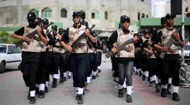 Sejumlah pelajar berbaris sambil memegang senjata kayu selama latihan militer di sebuah sekolah, Rafah, Jalur Gaza, Senin (28/3). Para pelajar dengan semangat diajarkan beberapa gerakan militer. (REUTERS / Ibraheem Abu Mustafa)