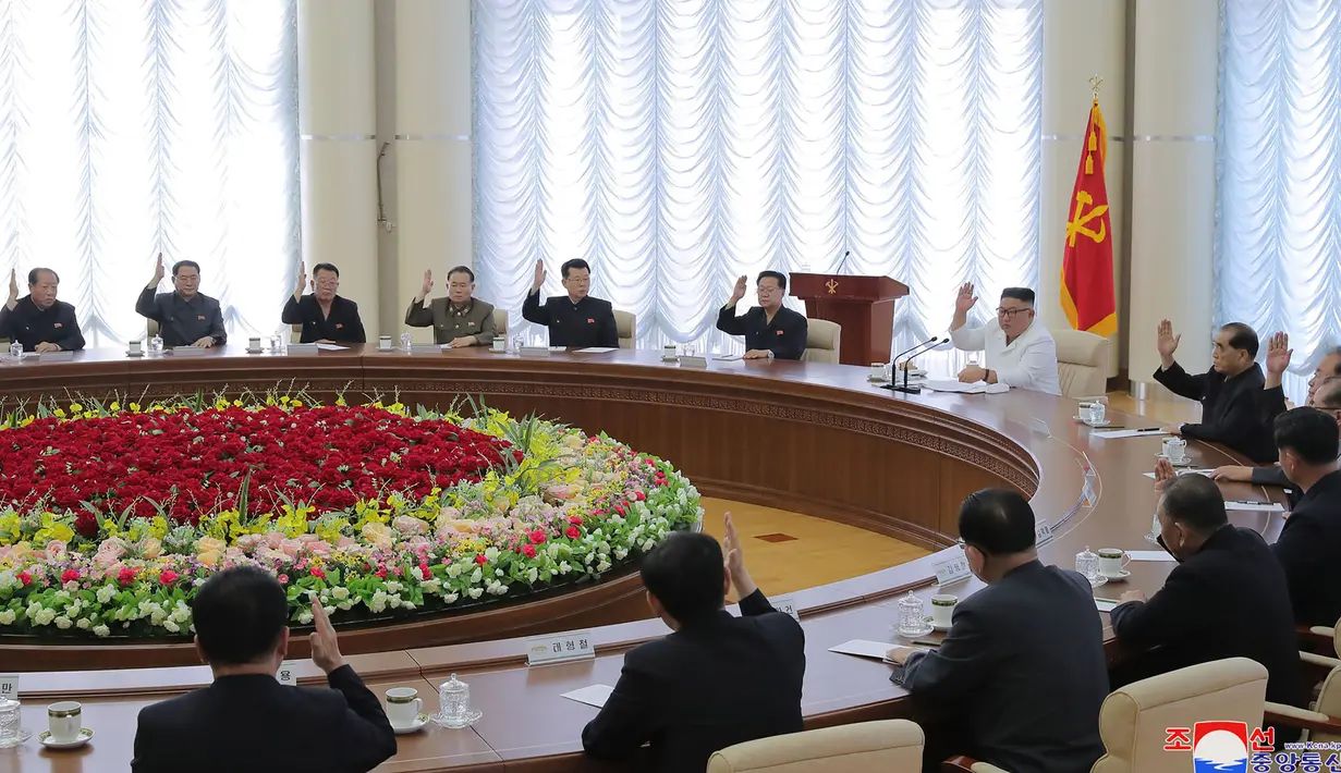 Pemimpin Korea Utara, Kim Jong-un (tengah-kanan) menghadiri pertemuan politbiro ke-13 dari Partai Buruh di lokasi rahasia dalam gambar yang diambil Minggu (7/6/2020). Dalam pertemuan itu, Kim Jong-un juga membahas proyek-proyek ekonomi termasuk industri kimia. (Photo by STR / KCNA VIA KNS / AFP)