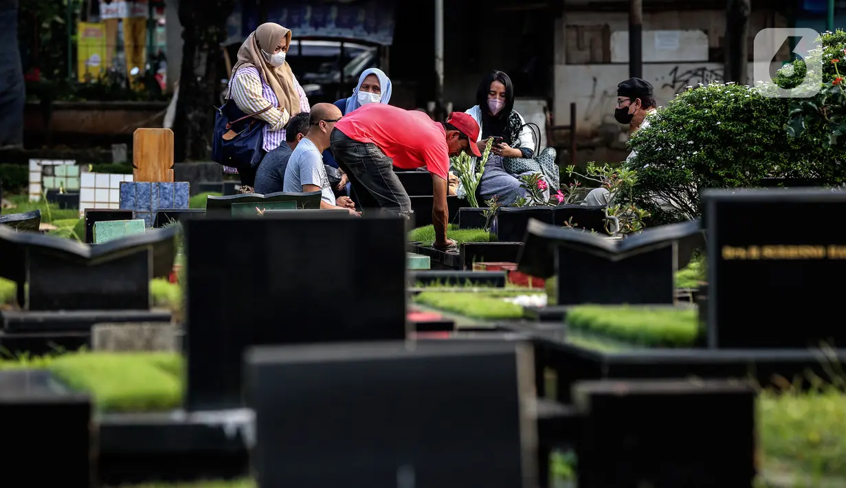 Warga berziarah di makam keluarganya di Tempat Pemakaman Umum (TPU) Tanah Kusir, Jakarta, Selasa (29/3/2022). TPU setempat semakin banyak dikunjungi warga yang melakukan tradisi ziarah kubur menjelang Ramadhan. (Liputan6.com/Johan Tallo)