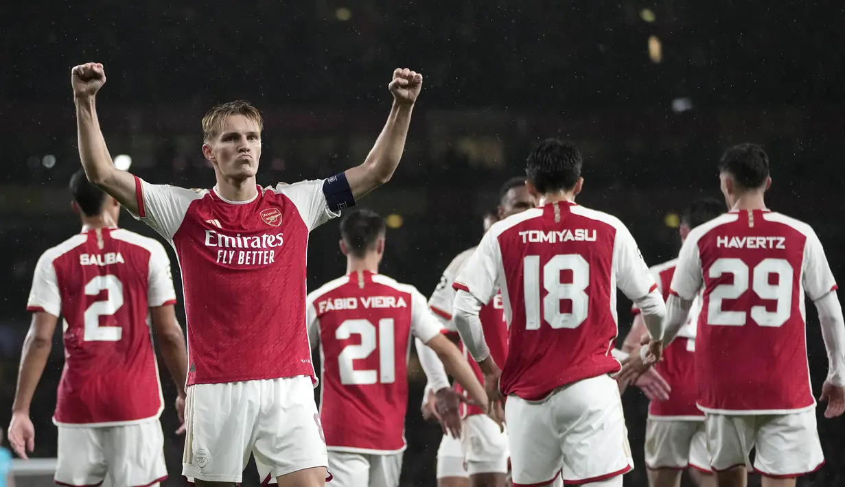 Pemain Arsenal, Martin Odegaard merayakan gol keempat tim bersama rekan-rekannya pada laga Grup B Liga Champions 2023/2024 melawan PSV Eindhoven di Emirates Stadium, London, Kamis (21/09/2023) dini hari WIB. (AP Photo/Kin Cheung)