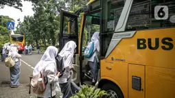 Pelajar menaiki bus sekolah usai pembelajaran tatap muka (PTM) di SMK Negeri 15, Kebayoran Baru, Jakarta Selatan, Jumat (3/9/2021). Dishub DKI Jakarta melalui Unit Pengelola Angkutan Sekolah membantu sarana transportasi gratis bagi peserta didik yang mengikuti PTM. (Liputan6.com/Faizal Fanani)