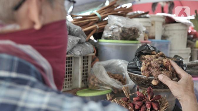 Pembeli memilih rempah-rempah yang dijual di Pasar Jatinegara, Jakarta, Kamis (26/3/2020). Merebaknya pandemi virus corona COVID-19 membuat penjualan jamu rempah-rempah seperti jahe, temulawak, dan kunyit meningkat pesat. (merdeka.com/Iqbal S. Nugroho)
